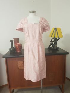 This is most likely late 1970s or early  1980s but  it has its design roots in the 1940s with its damask silk  rose print cocktail dress with its best feature being the pleated  fan shape shoulders. The dress is lined, darted thru the bodice and is a fit and flare line to below the knees . The dress has a back nylon zip and is in very good condition with no faults found.  The measurements are  Bust 92cm Waist 84cm Hips 103cm Length 102cm 1940 Clothing, Cocktail Dinner, Silk Rose, Dinner Dress, Silk Roses, Pink Silk, Rose Print, Dress Clothes For Women, Damask