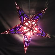 a purple and red lighted star hanging from the ceiling