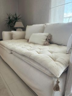 a white couch sitting next to a window in a living room