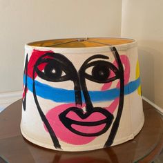 a lamp shade with a face painted on it