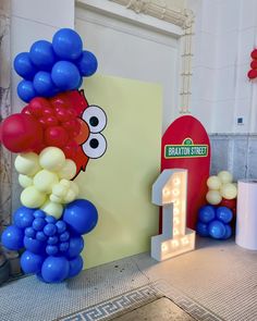 balloons are arranged around the number one sign