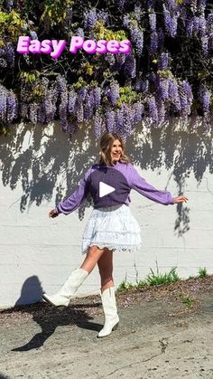 a woman standing in front of a white wall with purple flowers on it and the words easy pop above her