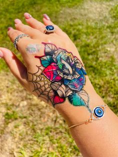 a woman's hand with tattoos on it and an eyeball in the center