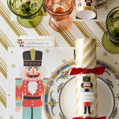 a table set with plates, napkins and place settings for a nutcracker themed party