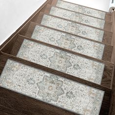 a set of stairs leading up to the top of a building with rugs on them