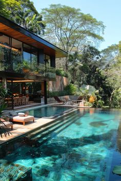 an outdoor swimming pool surrounded by greenery and trees, with lounge chairs on the side