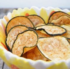 sliced up zucchini sitting in a yellow and white bowl on top of a wooden table