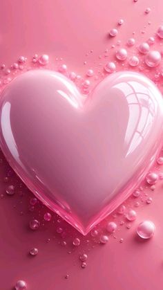 a pink heart shaped object with water droplets on the surface and bubbles all around it