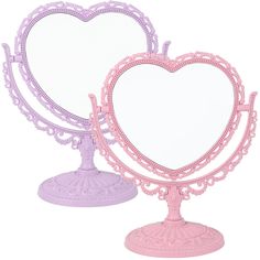 two pink heart shaped mirrors sitting next to each other