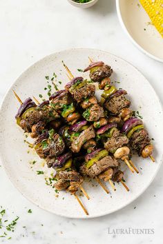 skewered meat and vegetables on a white plate