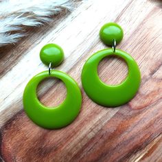 Moss Green Drop Hoop Earrings. I have made these fabulous statement drop hoop earrings in resin, using moss green colouring. The drop hoops have a classic 1950's style and measure 42mm in diameter. They are fixed to the top studs which are 17mm in diameter and have a 6mm dome. They are finished with stainless steel earring posts and have an total drop of 62mm. They are incredibly lightweight making them easy to wear. They will look amazing with your vintage summer dresses and also jeans and tops for a 50's rockabilly look. Please get in touch if you'd like these in a different colour combination, tops and hoops can be mixed or alternated if you would like mis-matched earrings. You can find more of my 50s and 60s drop hoop earrings here: www.etsy.com/uk/shop/RosieMays?section_id=25135598 Th Retro Green Drop Earrings, Retro Round Earrings For Party, Retro Party Earrings, Retro Dangle Jewelry, Retro Green Earrings For Party, Handmade Retro Green Jewelry, Green Retro Party Earrings, Vintage Green Hoop Earrings For Gift, Vintage Green Hoop Earrings Gift