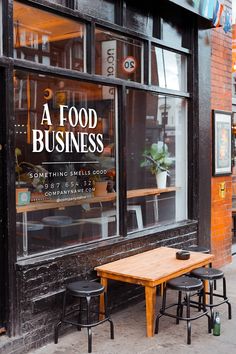 two wooden tables sitting in front of a restaurant window with the words a food business written on it