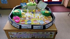 a table with some toys on it in the middle of a room and two children's books