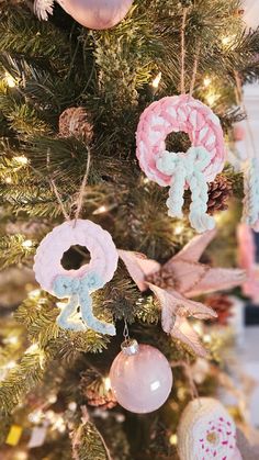 a christmas tree with ornaments hanging from it's branches and decorations on the top