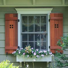 a window with wooden shutters and flower boxes