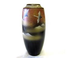 a black and brown vase sitting on top of a white table