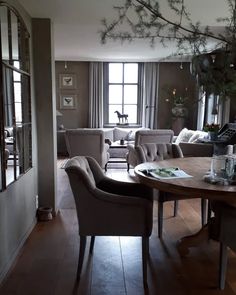 a living room filled with furniture next to a wooden floor covered in lots of windows