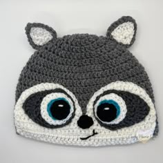 a crocheted raccoon hat with big eyes