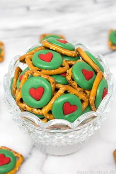 a glass bowl filled with cookies and pretzels