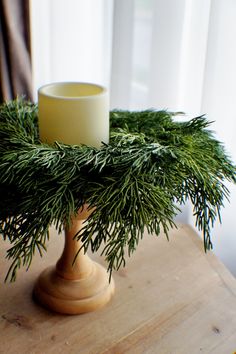 a candle is sitting on top of a pine branch