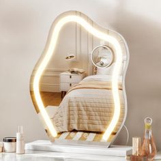 a bedroom with a bed and a large mirror on the wall above it that is lit up