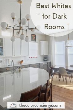 a kitchen with white cabinets and an island in the middle, surrounded by wooden flooring