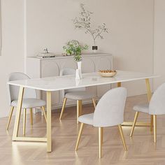 a dining room table with four chairs and a vase on the end shelf next to it