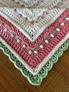 a crocheted blanket is laying on the floor