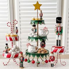 an assortment of nutcrackers, cookies and other holiday treats are displayed in front of a window