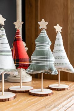 three small christmas trees sitting on top of wooden bases