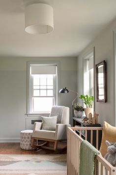 a baby's room with a rocking chair, crib and rugs on the floor