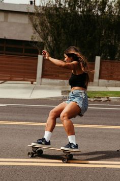 a woman riding a skateboard down a street