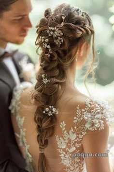 the back of a woman's head with flowers in her hair, wearing a wedding dress