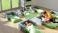 a woman is playing with her children in their bed beds on the floor next to each other