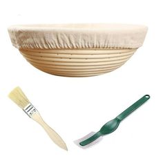 a wooden bowl with a brush next to it on a white background and a green handled spatula