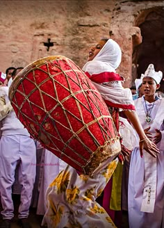 a group of people standing around each other in front of a large red heart shaped object