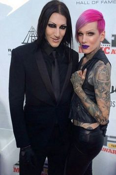 two people standing next to each other on a red carpet