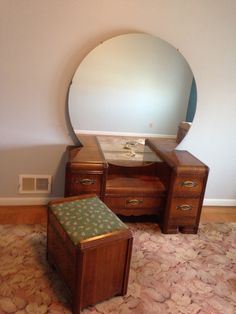 a mirror sitting on top of a wooden dresser next to a footstool and stool