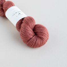 a skein of pink yarn sitting on top of a white surface