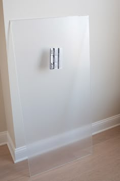 a white refrigerator freezer sitting on top of a hard wood floor next to a wall