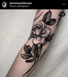 a black and white flower tattoo on the arm