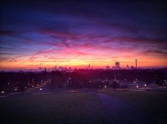 the sun is setting over a city skyline