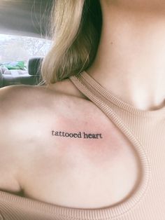 a woman with a tatooed heart tattoo on her shoulder