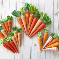 several carrots are arranged in rows on a white wooden surface with green and orange gingham checkered napkins