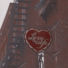 a sign on the side of a building that says love cafe with a red heart