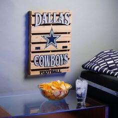 a bowl of chips sitting on top of a glass table next to a wooden sign