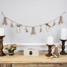 some candles are sitting on a table next to other decorations and decorating items in front of a white wall