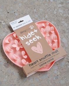 a heart shaped dish with hearts on it and a tag attached to the bowl that says hide seek