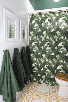 a bathroom with green towels hanging on the wall