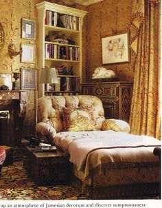 a living room filled with furniture and bookshelves next to a window covered in curtains